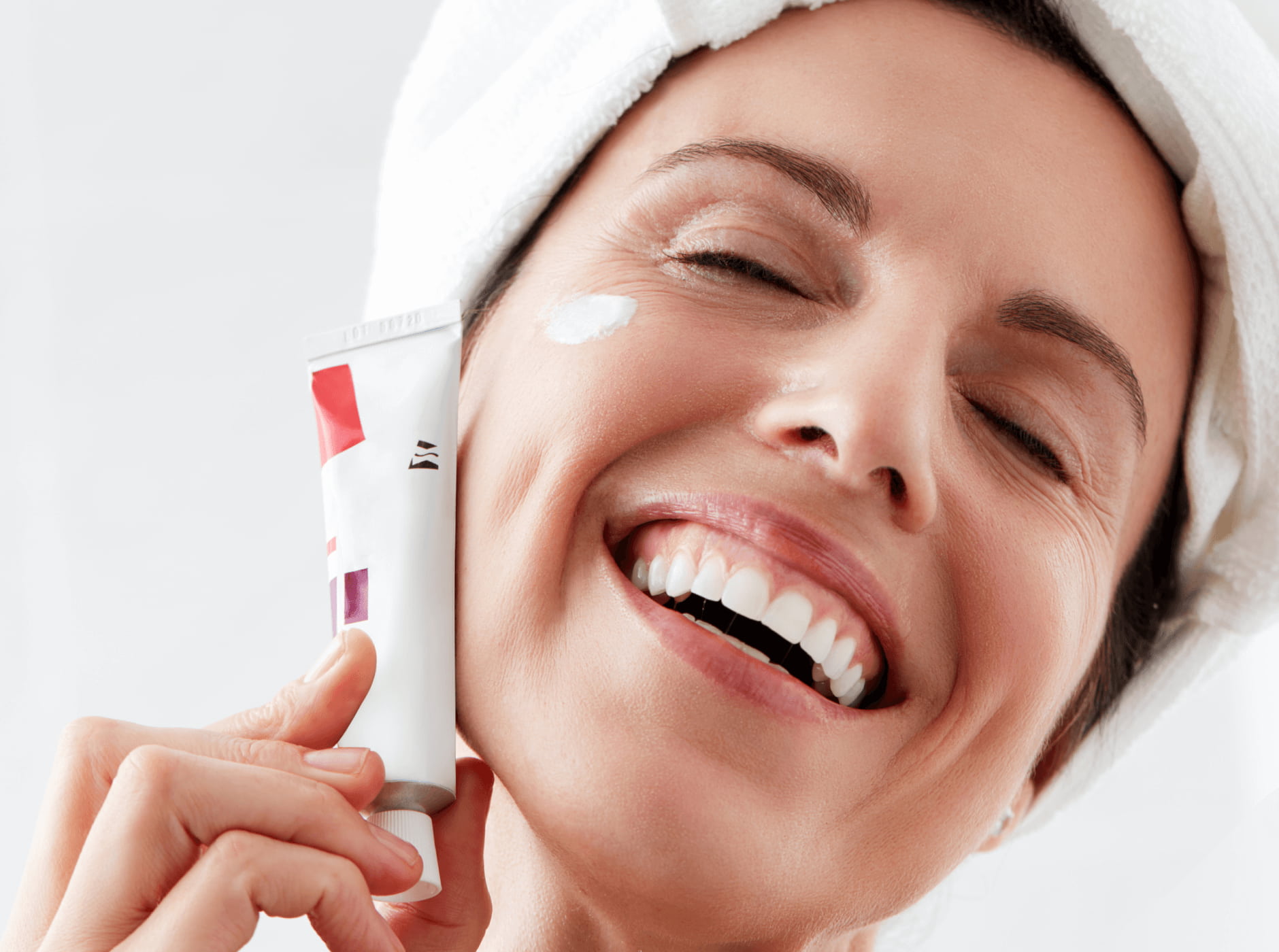 Women smiling with a cream tube